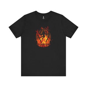 May include: Black t-shirt with a graphic of a creature in flames. The creature is surrounded by a circle of fire and the text "nalara" is below it.
