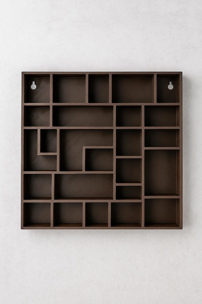 May include: A dark brown, geometric wall shelf with a variety of cubby sizes. The shelf is rectangular with a complex arrangement of square and rectangular compartments. Two keyhole slots are visible for hanging.