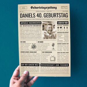 Peut inclure: Une carte d'anniversaire de style journal vintage avec une photo en noir et blanc d'un homme. Le titre principal est "Daniels 40. Geburtstag" et le sous-titre est "Nachrichten, Wirtschaft, Sport, Technologie, Filme und mehr lesen Sie alles &uuml;ber sein Geburtsjahr".