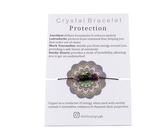 May include: A black string bracelet featuring amethyst, labradorite, black tourmaline, and smoky quartz crystals. The bracelet is displayed on a white card with the text "Crystal Bracelet Protection" and descriptions of the crystals' properties.