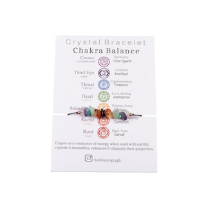 May include: A chakra bracelet with seven different colored stones, each representing a different chakra. The bracelet is made with copper wire and has a card with the names of the chakras and their corresponding colors. The card also includes the text "Crystal Bracelet Chakra Balance".