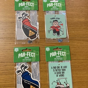 May include: Four golf-themed air fresheners in clear packaging. Two feature golf bags with the text "How's my driving?" and "Car-fect". The other two have a cartoon golfer and a golf cart with the text "A bad day at golf is better than a good day at work!"