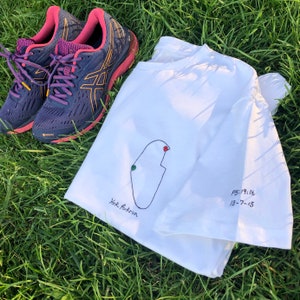 Op de afbeelding: Wit T-shirt met een handgetekend kaartje van een hardlooproute en de tekst "York Parkrun" en "PB:19:16 18-7-15".