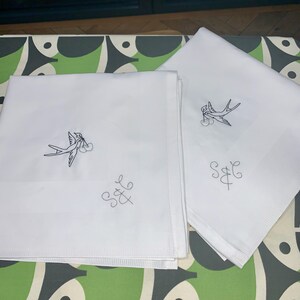 以下が含まれることがあります： 刺繍された鳥とイニシャル「S&E」が施された白いリネンナプキン2枚
