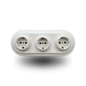 Op de afbeelding: Een wit drievoudig stopcontact met een gladde, afgeronde rechthoekige afdekplaat. De unit bevat drie cirkelvormige stopcontacten die horizontaal zijn gerangschikt, elk voorzien van twee openingen en aardingscontacten aan de boven- en onderzijde.