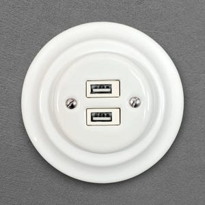 Peut inclure: Une tasse en céramique blanche avec une anse noire et le texte "But First, Coffee" en noir, en gras. La tasse est posée sur une surface blanche.