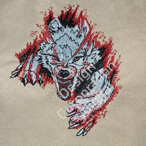 Puede incluir: Dise&ntilde;o bordado de un lobo blanco con ojos rojos, rompiendo a trav&eacute;s de un fondo rojo y negro. La boca del lobo est&aacute; abierta y sus dientes son visibles.