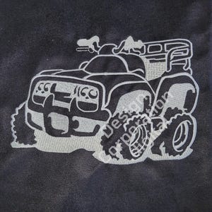 Puede incluir: Un diseño bordado blanco de un ATV sobre un fondo de tela negro.