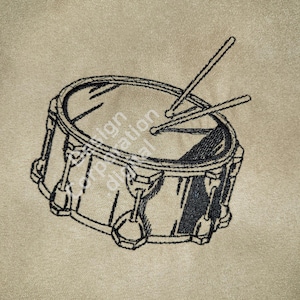 May include: A black and white line drawing of a drum with two drumsticks.