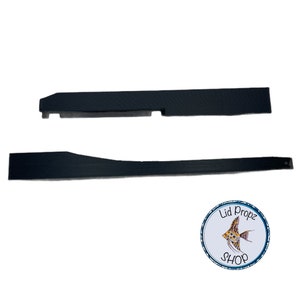 May include: Two black plastic pieces for a fish tank lid. The pieces are flat and rectangular with a slight curve in one of the pieces.