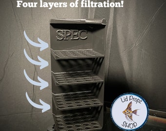May include: Black plastic filter media holder with four shelves and the word "SPEC" printed on the front. The holder is designed to hold filter media for aquariums. The image shows four arrows pointing to the holder, indicating the direction of water flow through the filter media.