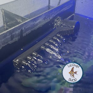 Spray bar installed in a Fluval Flex tank, attached to the ball joint output nozzle. Water flows gently across the tank through multiple outlets, creating smooth circulation without stressing fish.