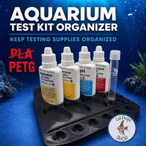 May include: A black plastic aquarium test kit organizer with multiple circular cutouts for bottles and a test tube. The organizer holds four white test solution bottles labeled Ammonia, pH, and Range, alongside a clear glass test tube.