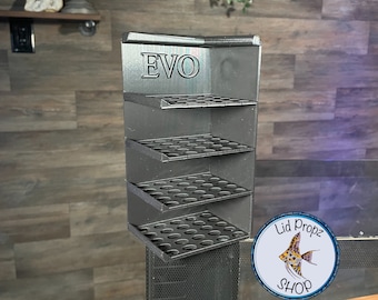 May include: Black plastic organizer with four shelves and the word "EVO" printed on the front. Each shelf has multiple round holes for holding small items. The organizer is mounted on a black surface.
