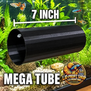 Peut inclure: Un tube cylindrique noir à la surface texturée, étiqueté comme un méga tube de 17,78 cm. Le tube présente une petite ouverture circulaire sur le côté et est conçu pour être utilisé dans un aquarium, offrant un espace creux pour la vie aquatique.