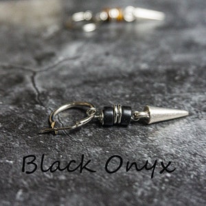May include: Silver hoop earring with a black onyx bead and a silver spike. The earring is on a gray background.