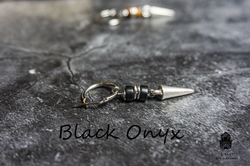 May include: Silver hoop earring with a black onyx bead and a silver spike. The earring is on a gray background.