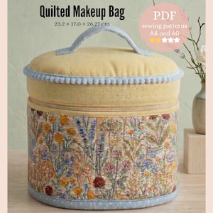 Op de afbeelding: Een gewatteerde make-uptas met een bloemenpatroon en een gele bovenkant. De tas heeft een handvat en meet ongeveer 23,2 x 17,0 x 26,27 cm. De tekst "Quilted Makeup Bag" is zichtbaar op de afbeelding.