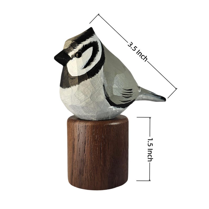 May include: A hand-carved wooden bird figurine, 3.5 inches long, in shades of gray, black, and white, perched on a 1.5-inch brown wooden base. The bird has detailed feather and eye markings, creating a realistic appearance. A decorative item.