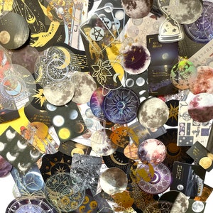 May include: A collection of celestial-themed stickers and ephemera. The assortment includes moon phases, sunbursts, tarot card imagery, and various celestial designs in shades of gold, black, and white. Some pieces feature holographic accents and text.