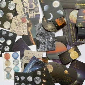 May include: A collection of decorative paper ephemera featuring celestial and landscape designs. The assortment includes stickers and cards with images of moons, planets, and ocean scenes. Some cards have text in English and Chinese.