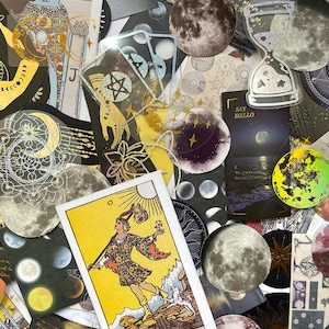 May include: A collection of celestial-themed stickers and cards. The image features moon-shaped stickers, tarot cards, and other decorative elements with gold foil accents. The tarot card shows a figure with a dog, the word "NEBUNUL" is visible.