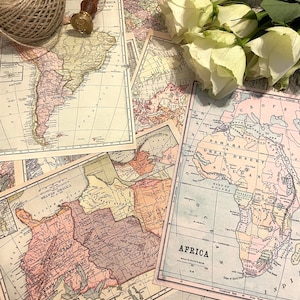 Puede incluir: Un surtido de mapas antiguos con un ovillo de cuerda, un sello de cera y rosas blancas. Los mapas muestran continentes como África y América, con detalles geográficos y texto histórico. La paleta de colores incluye beige, rosa y verde.