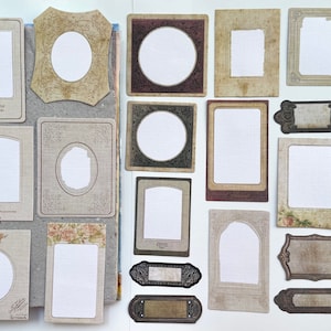 Op de afbeelding: Een verzameling papieren frames en labels in vintage-stijl in verschillende vormen en maten. De frames hebben sierlijke ontwerpen, bloemaccenten en verouderde texturen in beige, bruin en groen. Sommige frames hebben tekst.