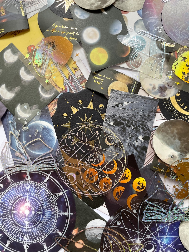 May include: A collection of celestial-themed stickers and ephemera. The assortment includes various shapes and sizes, featuring moons, stars, and astrological symbols. Some stickers have holographic and glitter accents, with text that reads "Life is limited".
