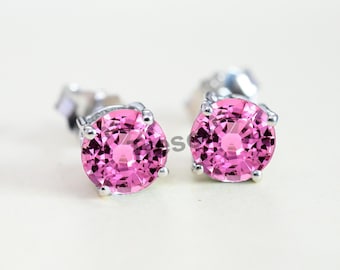 May include: A pair of silver stud earrings with pink round gemstones.