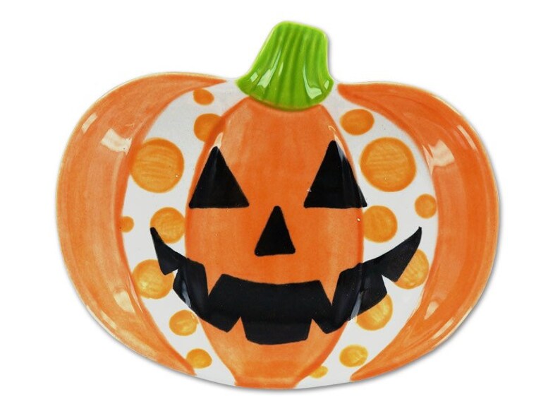 Puede incluir: Plato de calabaza de cer&aacute;mica naranja y blanco con una cara de calabaza negra y lunares naranjas.