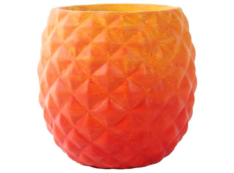 Puede incluir: Maceta de cer&aacute;mica naranja y roja con forma de pi&ntilde;a y superficie texturizada.