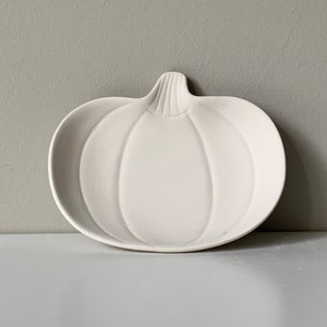 Puede incluir: Plato de cer&aacute;mica blanco con forma de calabaza. El plato est&aacute; dise&ntilde;ado para parecer una calabaza con un tallo y nervaduras.