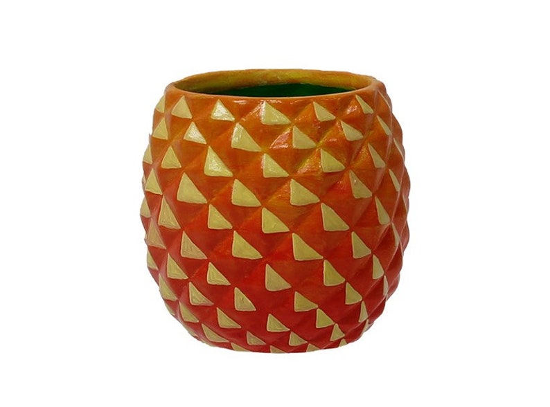 Puede incluir: Maceta de cer&aacute;mica en forma de pi&ntilde;a naranja y amarilla con un patr&oacute;n geom&eacute;trico.