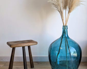 Taburete antiguo de madera maciza de estilo rústico brutalista.