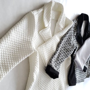 May include: A white quilted jacket with a black and white patterned jacket, a black jacket, a grey jacket, and a white jacket.