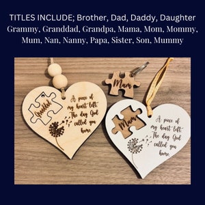 May include: Two wooden heart-shaped ornaments with a puzzle piece cutout. The top ornament is light brown with the text "Granddad" and the words "A piece of my heart left. The day God called you home." The bottom ornament is white with the text "Mum" and the words "A piece of my heart left. The day God called you home."