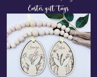 May include: Two wooden Easter egg-shaped gift tags featuring bunny and floral designs. The tags are personalised with the names "George" and "Sofia".