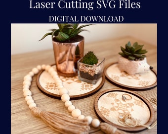 May include: Three wooden trinket trays with an Aztec-inspired geometric design. The trays are on a wooden surface with a small potted plant, a glass jar with rocks, and a small ceramic hedgehog.