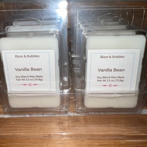 May include: Several clear plastic packages of soy blend wax melts. Each package contains a white, rectangular wax melt labeled "Vanilla Bean" with the brand "Blaze & Bubbles". Each melt weighs 2.5 oz (70.9g).