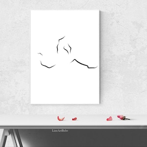 Puede incluir: Una impresi&oacute;n de arte en l&iacute;nea negra y blanca de una figura humana estilizada, enmarcada y colgada en una pared blanca. La impresi&oacute;n est&aacute; sobre una mesa blanca con algunos p&eacute;talos de rosa rosa en la superficie.
