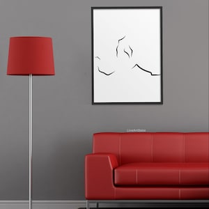 Puede incluir: Una impresi&oacute;n de arte en l&iacute;nea negra y blanca de un dise&ntilde;o abstracto en un marco negro que cuelga de una pared gris sobre un sof&aacute; de cuero rojo. El texto "LineArtBabe" est&aacute; impreso debajo del marco.