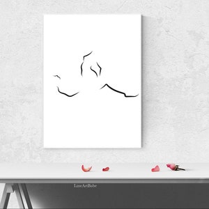 Puede incluir: Una impresi&oacute;n de arte en l&iacute;nea negra y blanca de una figura humana estilizada, enmarcada y colgada en una pared blanca. La impresi&oacute;n est&aacute; sobre una mesa blanca con algunos p&eacute;talos de rosa rosa en la superficie.