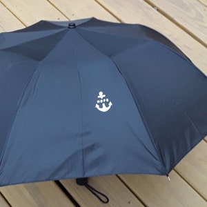 May include: Black umbrella with a white anchor and the word "HOPE" printed on it.