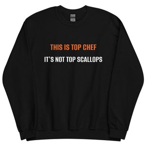 May include: Black sweatshirt with white text that reads "This is Top Chef It's Not Top Scallops" in orange.