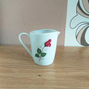 May include: White ceramic creamer with a single red rose design.