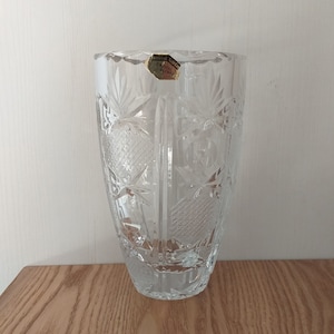 May include: A clear glass vase with a cut glass design. The vase has a label that reads "Crystal Czech Bohemia".