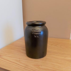 Könnte beinhalten: Eine schwarze Keramikvase mit dem Text "RÖGANÄS STENSÖDER KL" auf der Seite.