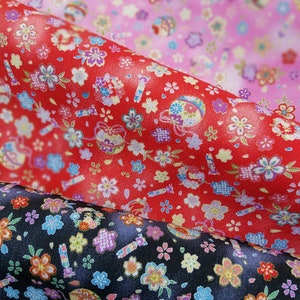 May include: Three fabric swatches with a repeating pattern of flowers and other designs. The top swatch is pink with white flowers, the middle swatch is red with white flowers, and the bottom swatch is black with white flowers.