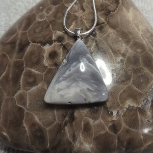 Könnte beinhalten: Eine silberne Kettenkette mit einem dreieckigen Anhänger aus weißem und grauem Achat.